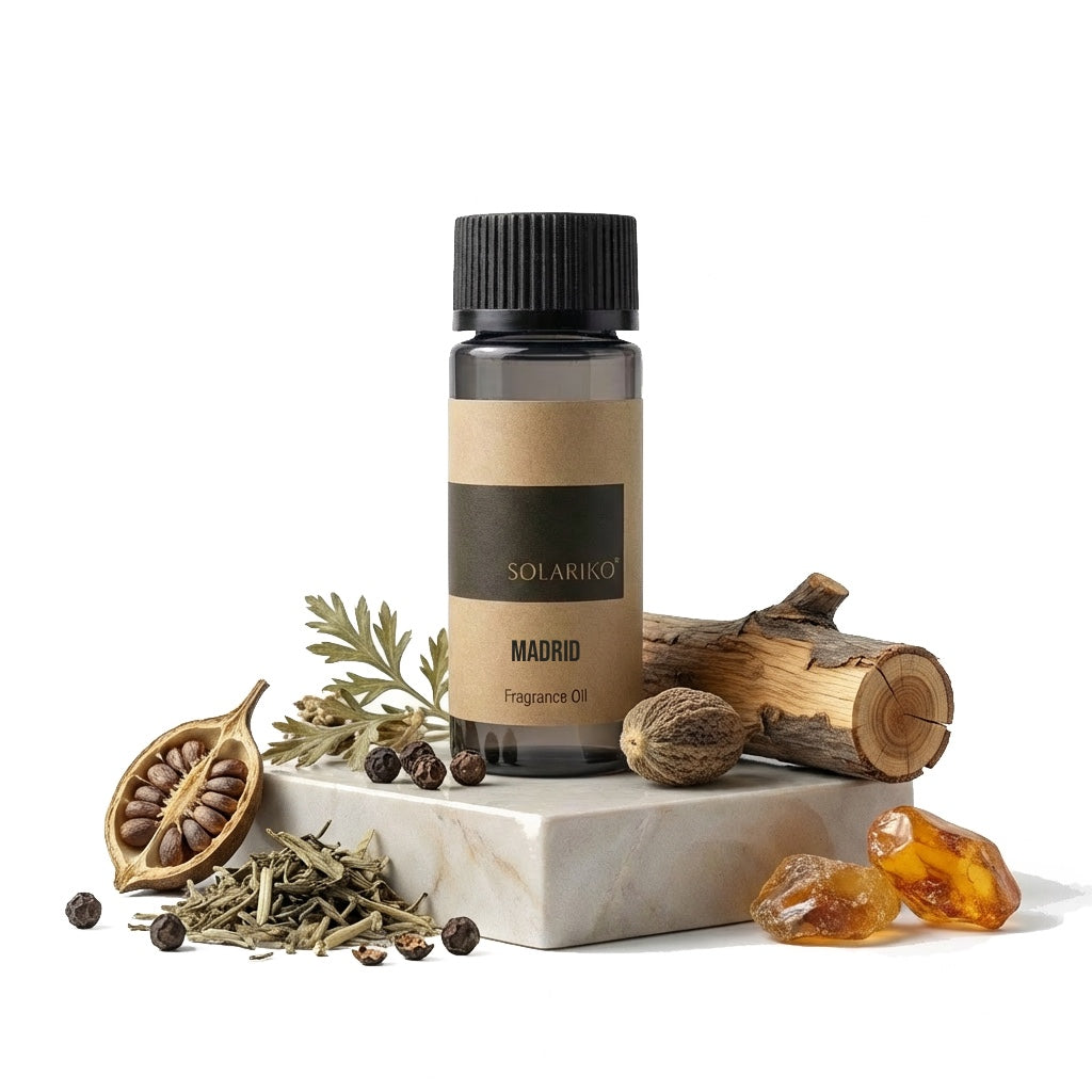 Fragrance Oil - Madrid in a black bottle with natural elements like wood, herbs, and amber stones.