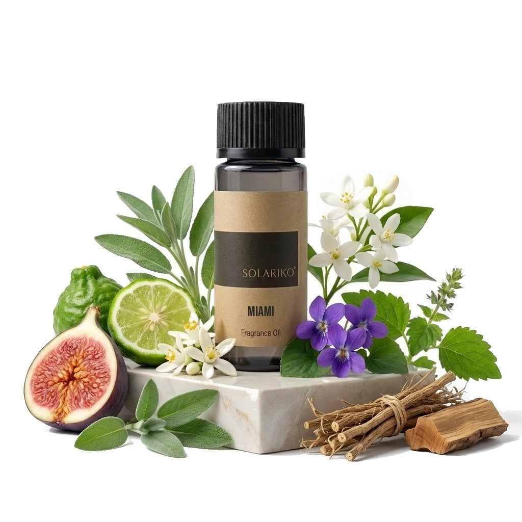 Fragrance Oil - Miami in a bottle surrounded by herbs, flowers, and fruits like fig and lime on a stone base.