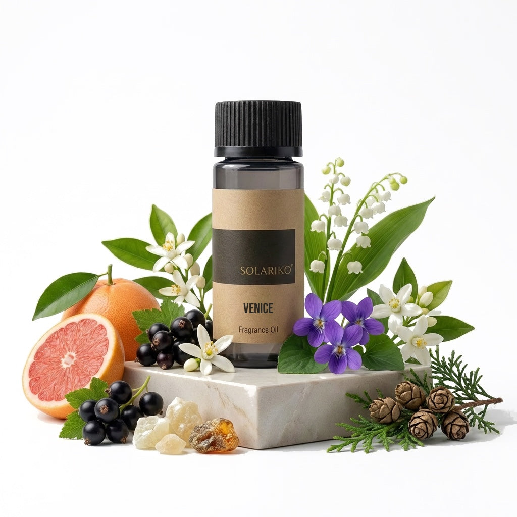 Fragrance Oil - Venice in a bottle surrounded by citrus, flowers, and greenery on a marble base.